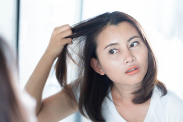 Woman looking reflection in the mirror serious hair loss problem for health care shampoo and beauty...