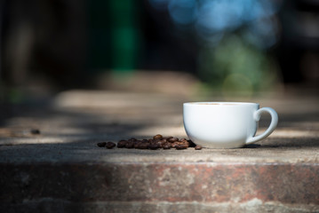 Cup of coffee and coffee beans on a stone background