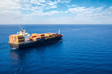 Luftaufnahme eines Containerschiffes in langsamer Fahrt auf offenem Meer