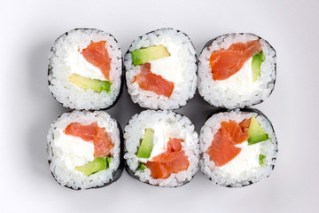 Close up fresh prepared sushi rolls with avocado, red fish salmon and whit cheese filadelfia in black nori. Top view