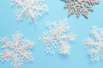 Christmas or winter composition. Frame made of snowflakes and red berries on pastel blue background. Christmas, winter, new year concept. Flat lay, top view, copy space