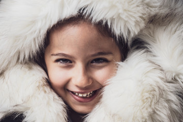 Close up portrait of a young girl dressed with an eskimo jacket  looking at the camera