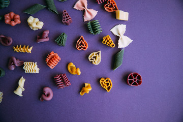 Multicolored pasta shapes on colorful background. 
