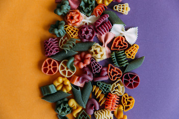 Obraz na płótnie Canvas Multicolored pasta shapes on colorful background. 