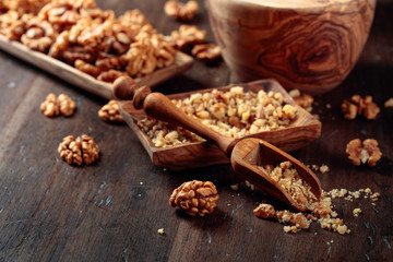Walnuts in a wooden dish on an old wooden table.
