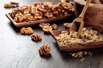 Walnuts in a wooden dish on an old wooden table.