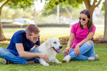 Couple lying in the park while having fun with the dog.happy family concept