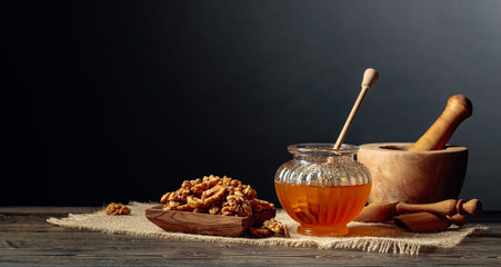 Healthy breakfast background. Honey and walnut on a black background.