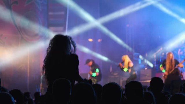 Crowd of fans are cheering at open-air rock concert