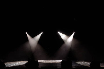 The light of searchlights in smoke on stage of the theatre.