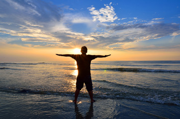 Silhouette of Man Raising His Hands or Open arms when sun rising up