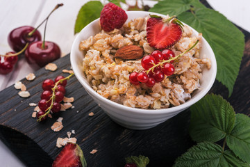 oat flakes breakfast with berries  on wooden background