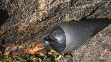 Obraz premium A black and grey bumper - fender - from a boat keyed hard between two mountains nearby the sea at the Swedish west coast. 