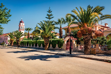 Amazing spring view of the street of Karavomylos village with St. John church on background. Sunny morning scene of Kefalonia island, Greece, Europe. Traveling concept background.
