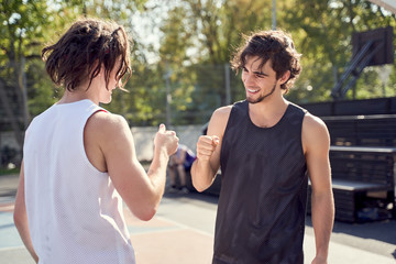 Picture of happy two athletes shaking hands on sports field.