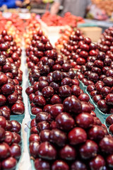 Fresh cherries in an indoor farmers market.  The market is Granville Market, in Vancouver, Canada