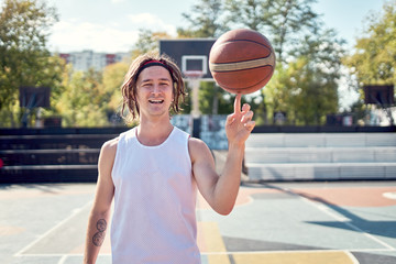 Image of athlete man in white T-shirt with ball in his hands on playground.