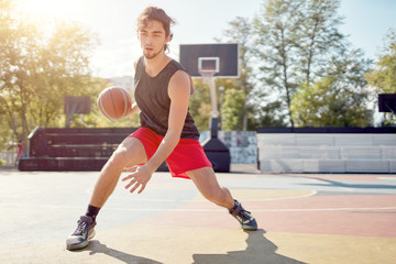 Obraz premium Photo of athlete in blue T-shirt playing basketball on playground