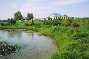 Fototapeta na wymiar City Brukna, Latvia Republic. Park with old manor. Trees and green zone. Sep 9. 2019 Travel photo.
