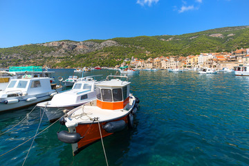 View on port on Adriatic Sea, moored boats and old buildings, island Vis, Komiza, Croatia