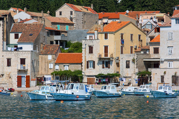 Fototapeta premium View on port on Adriatic Sea, moored boats and old buildings, island Vis, Komiza, Croatia