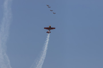 Different jets flying in the blue sky and performing a show leaving smoke marks
