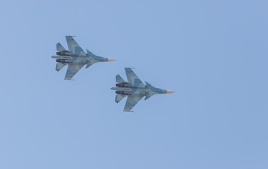 Fototapeta na wymiar Two military fighter jets flying in the clean blue sky - side view