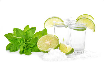 Tequila shot with juicy lime slice and salt on white background