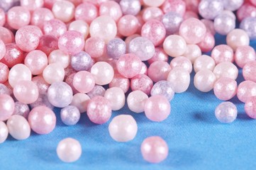 Decor for baking, colored pearls pattern on blue background. sugar pearls, Used as a decoration or to add texture to cupcakes, cookies, cakes, doughnuts, ice cream, frozen yogurt and puddings.