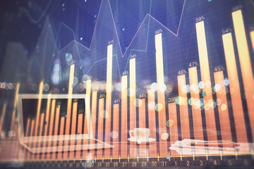 Stock market graph on background with desk and personal computer. Multi exposure. Concept of financial analysis.
