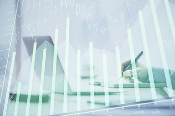 Multi exposure of forex chart with man working on computer on background. Concept of market analysis.