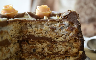Cake with nuts and meringues decorated with cream rose. Shallow depth of field, close-up.