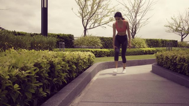 Beautiful sport woman twitch leg, hamstring, thigh, sprain ankle during jogging on the lane. Runner woman get spasm, injured hamstring while running and sit on footpath or She get cramp at her legs