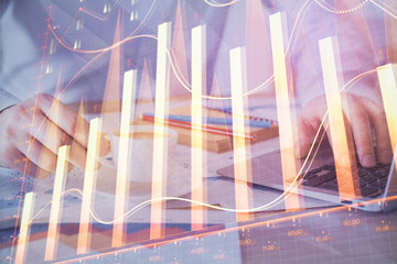Forex graph with businessman working on computer in office on background. Concept of hardworking. Double exposure.