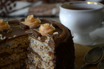 Cake with nuts and meringues decorated with cream rose. Shallow depth of field, close-up.