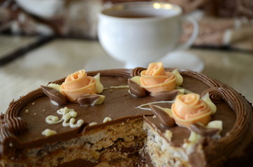 Cake with nuts and meringues decorated with cream rose. Shallow depth of field, close-up.