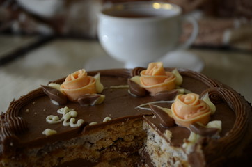 Cake with nuts and meringues decorated with cream rose. Shallow depth of field, close-up.
