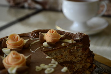 Cake with nuts and meringues decorated with cream rose. Shallow depth of field, close-up.
