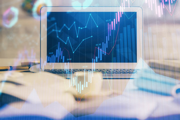 Financial graph colorful drawing and table with computer on background. Multi exposure. Concept of international markets.