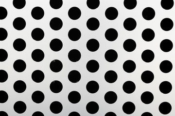 Rapid black big dot pattern on white background, round holes texture on perforated metal panel surface, close-up.