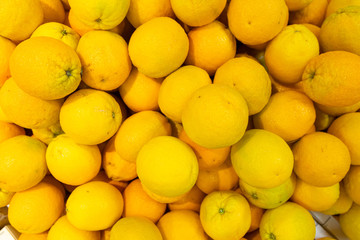 Bright yellow lemons in wooden boxes at farmer's market or grocery store aerial view. May be used for background. Top view.