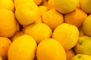 Bright yellow lemons in wooden boxes at farmer's market or grocery store. May be used for background. Aerial view close-up