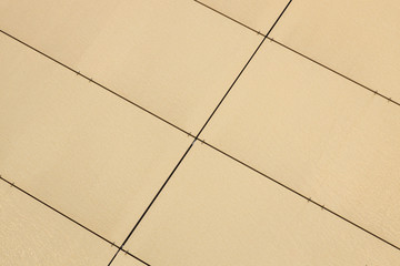 Close-up of pale yellow-beige rightangled tiles on wall
