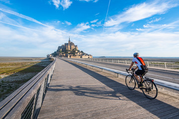 Cyclist driving on the only access road to Mont Saint Michael. The bicycle is one of the options allowed for access