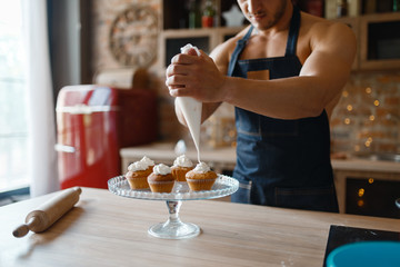 Nude man in apron cooking dessert on the kitchen