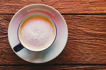 cup of coffee with whipped cream on wooden background