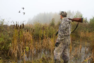 Foto op Plexiglas the hunter looks after the departing ducks © rodimovpavel