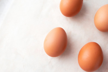 Close-up organic eggs on marble background and copy space, above. Easter minimalism concept