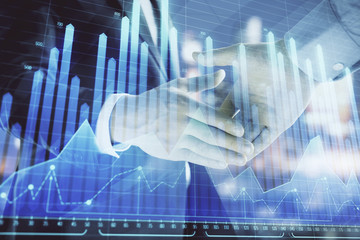 Double exposure of financial chart on cityscape background with two businessmen handshake. Concept of financial analysis and investment opportunities