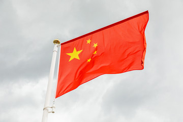 flag of China against white sky with clouds